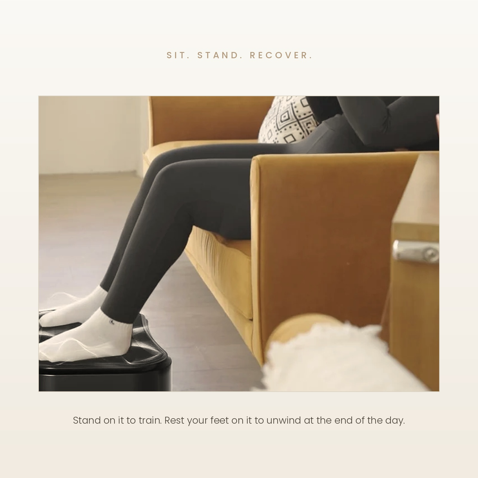 A person seated on a tan sofa wearing black leggings and white socks, with their feet resting on a black foot-train device. The scene is styled with a warm neutral background and text above and below reading 'SIT.
